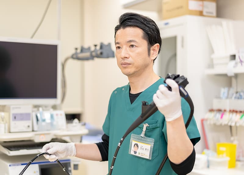 内視鏡を持つ秋山祖久院長の写真